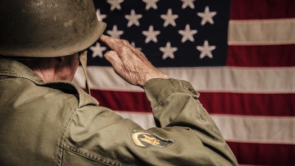 Veteran saluting American flag